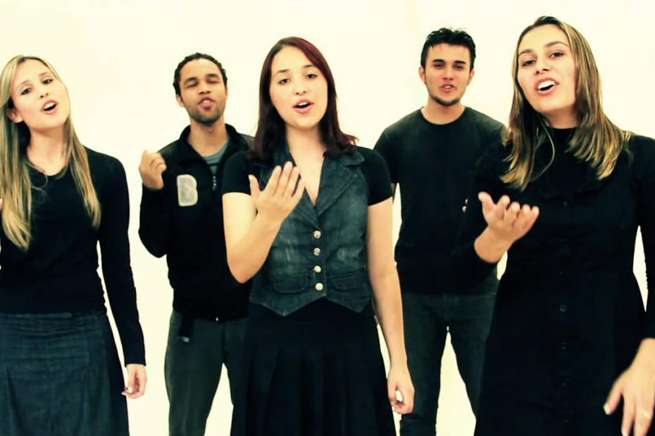 Miniatura do vídeo "Orei Por Você", do Coral Projeto Volta, mostra membros do coral interpretando a música com as mãos levemente estendidas para a frente